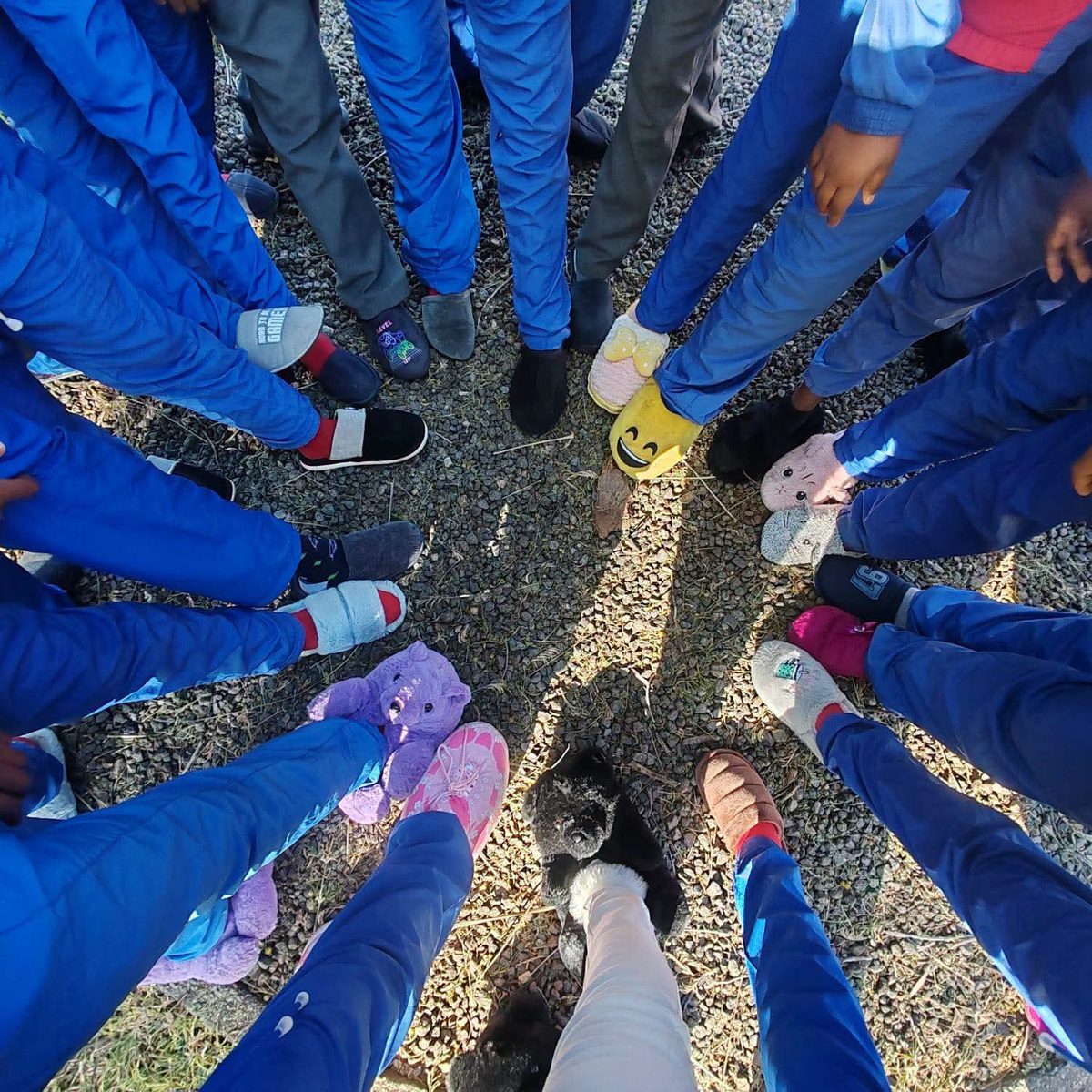 Learners standing in a circle showing off their fluffy slippers on Pyjama Day